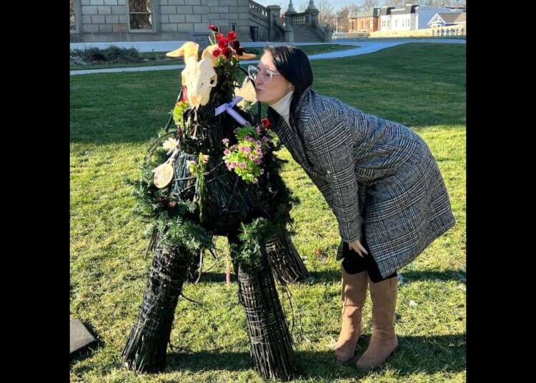 Samantha Skorka kisses a satanic display at the Michigan state Capitol in Lansing.